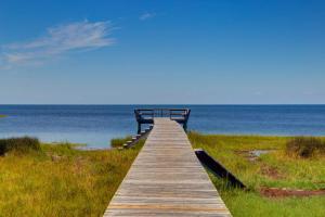 a wooden boardwalk leading to the ocean on a beach at Hotter Otter-6 beds-private pool-kid/pet friendly-walk to beach! in Rodanthe