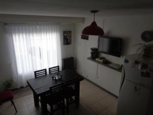 a kitchen with a dining room table and a refrigerator at La Casa de Marite Apart, un lugar para disfrutar in El Calafate