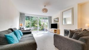 a living room with two couches and a tv at Castle Acre, Mumbles in The Mumbles