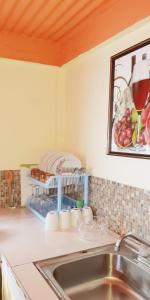 a kitchen counter with a sink and a picture on the wall at "SunRise Inn" Nature Island Dominica 