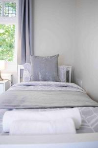Bett in einem weißen Zimmer mit Fenster in der Unterkunft Reading Spacious Stay, NHS & Contractors in Reading