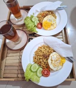 two plates of food on a table with drinks at D' Senayu in Masbagik