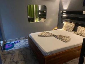 Un dormitorio con una cama con una pajarita. en Sunrise Center Bonapriso - 109 en Duala