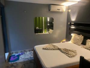 a bedroom with a bed with a tie on it at Sunrise Center Bonapriso - 109 in Douala