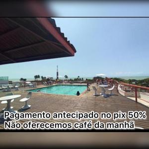 una vista de una piscina con gente sentada a su alrededor en Victory Flat Tambaú BR, en João Pessoa