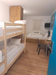 a room with two bunk beds and a desk at T3 Budget Berlin Hennigsdorf in Hennigsdorf