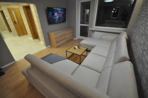 a living room with a white couch and a table at JDK Apartamenty Legionów 74m2 8-osobowy in Kalisz
