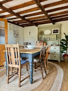 Grundisburgh的住宿－Charming 3 bedroom house in Woodbridge area，一间配备有蓝色桌子和椅子的用餐室