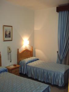 坎皮約斯的住宿－聖弗朗西斯科旅館，酒店客房,设有两张床和一盏灯