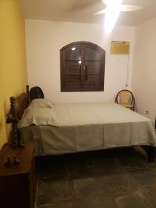 a small bedroom with a bed and a window at Casa Praia Jd Acapulco in Guarujá