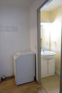 a bathroom with a sink and a white refrigerator at Ha-Py Friends in Campan