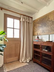 a living room with a window and a wooden cabinet at Charming 3 bedroom house in Woodbridge area in Grundisburgh