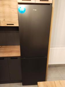 a black refrigerator freezer sitting in a kitchen at Prawnicza50 in Żory