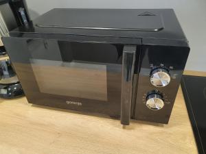 a black toaster oven sitting on top of a table at JDK Apartamenty Legionów 74m2 8-osobowy in Kalisz