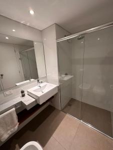 a bathroom with a sink and a shower and a toilet at Apartamento frente al lago in Montevideo
