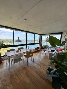 a living room with a table and chairs and windows at Apartamento frente al lago in Montevideo