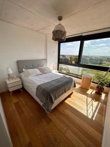 a bedroom with a large bed and a large window at Apartamento frente al lago in Montevideo
