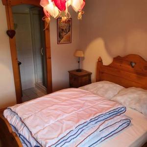 1 dormitorio con cama y lámpara de araña en Appartement Samoëns centre 5 pers. Villa Monette, en Samoëns