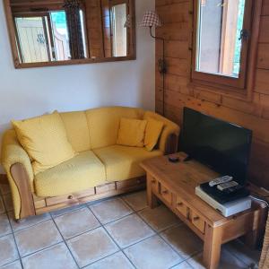- un salon avec un canapé jaune et une table basse dans l'établissement Appartement Samoëns centre 5 pers. Villa Monette, à Samoëns
