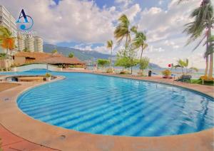 a large swimming pool with a view of the ocean at 5 Departamento con Espectacular Vista a la Bahía de Acapulco in Acapulco