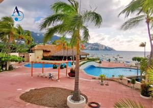 a resort with a swimming pool and the ocean at 5 Departamento con Espectacular Vista a la Bahía de Acapulco in Acapulco