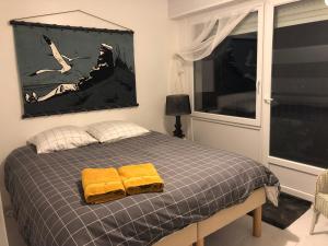 a bedroom with a bed with two yellow towels on it at T2 Vue MER COSY HORIZON PLAGE in Plérin