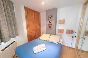1 dormitorio pequeño con 1 cama azul y 2 toallas en Ski Plaza Sierra Nevada & Zona Baja, en Sierra Nevada