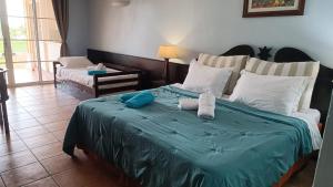 a bedroom with a large bed with a blue blanket at studio 4 pers vue mer et cocotiers dans Village Vacances Sainte-Anne Pointe du Helleux plage à - 30 m in Sainte-Anne