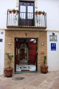 una entrada a un edificio con balcón y macetas en Apartamentos Medina Qurtuba en Córdoba