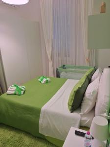 a bedroom with a large bed with a green blanket at appartamento in firenze la lamma in Florence