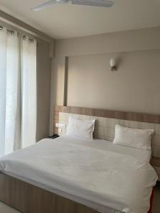 a large white bed in a room with a window at Omaxe krishna luxury stays in Vrindāvan