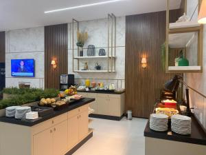 a kitchen with a counter with plates of food on it at Hotel Villa Cerrado in Nova Mutum