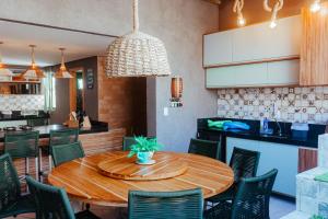- une salle à manger avec une table et des chaises en bois dans l'établissement Triplex Temporada Areia e Mar Patacho - Casa Verde, à Porto de Pedras