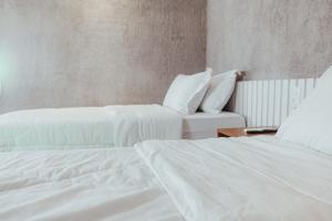 - 2 lits dans une chambre avec des draps blancs dans l'établissement Triplex Temporada Areia e Mar Patacho - Casa Verde, à Porto de Pedras