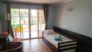 圣安尼Grand studio 4 pers superbe vue mer et cocotiers dans Village Vacances Sainte-Anne plage à - 30 m的带床和滑动玻璃门的卧室