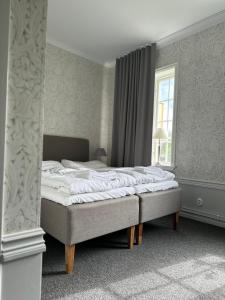 a bed sitting in a bedroom with a window at Crusellska Vandrarhemmet in Strömstad