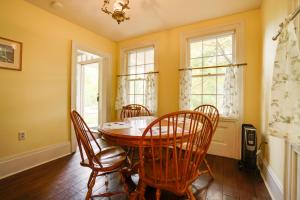 a dining room with a table and chairs and windows at Historic Home in Taylors Falls with Patio and Fire Pit in Taylors Falls