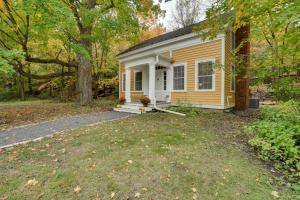 une petite maison jaune et blanche avec une cour dans l'établissement Historic Home in Taylors Falls with Patio and Fire Pit, à Taylors Falls