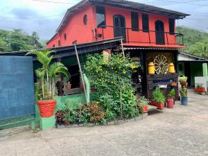 a red building with plants in front of it at Pousada Quinta de Areal in Areal