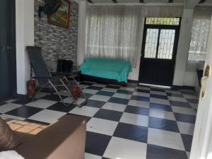 sala de estar con sofá verde y suelo de tablero de ajedrez en Casa vacacional Honda Tolima, en Honda