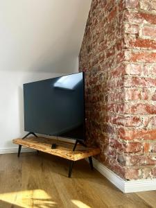 einen Flachbild-TV an einer Backsteinwand in der Unterkunft Schickes Studio in bester Lage in Bad Salzuflen