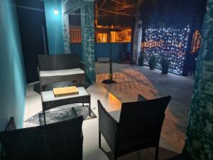 Pousada D’San Shower & Bed في فينهيدو: غرفة بها كراسي وطاولة وأضواء