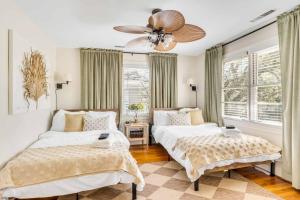 a bedroom with two beds and a ceiling fan at The Grand Millennial in Downtown Charleston in Charleston