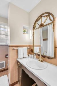 a bathroom with a sink and a mirror at The Grand Millennial in Downtown Charleston in Charleston