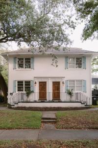 une maison blanche avec deux portes et un peu d'herbe dans l'établissement The Grand Millennial in Downtown Charleston, à Charleston