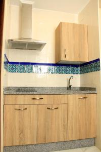 una cucina con armadi in legno e lavandino di Apartamentos Medina Qurtuba a Cordoba