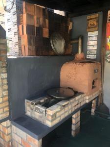 un horno de ladrillo con una sartén encima en Hostel Bombinhas, en Bombinhas