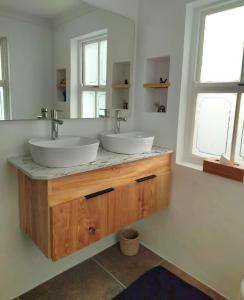 a bathroom with two sinks and two windows at House On The Hill in Cape Town