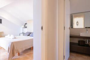 a white bedroom with a bed and a sink at Jávea terraza + piscina + vistas al mar in Platja de l'Arenal