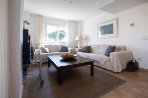 a living room with a couch and a table at Jávea terraza + piscina + vistas al mar in Platja de l'Arenal